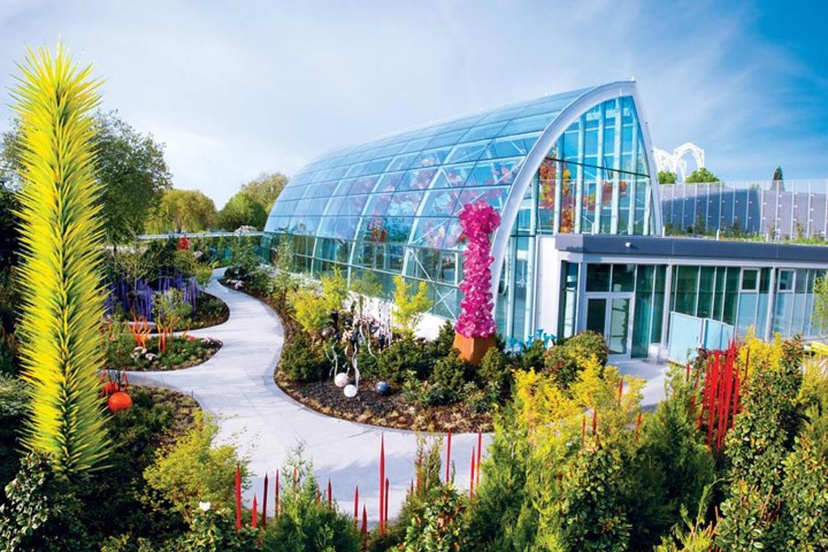 a large glass building with plants in front of it