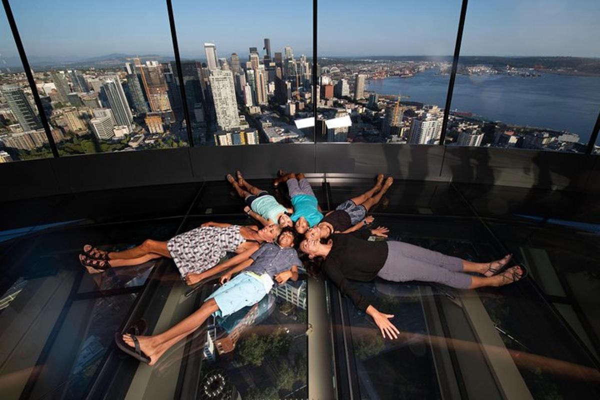 a group of people laying on the glass floor of a building