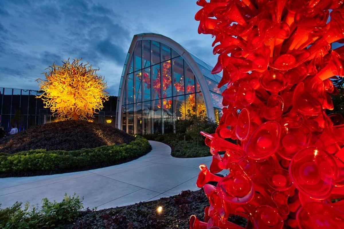 a red sculpture in front of a glass building