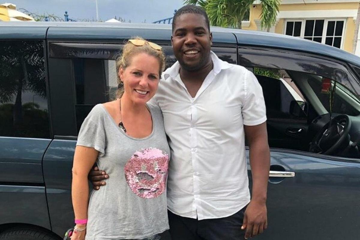 a man and a woman standing in front of a car