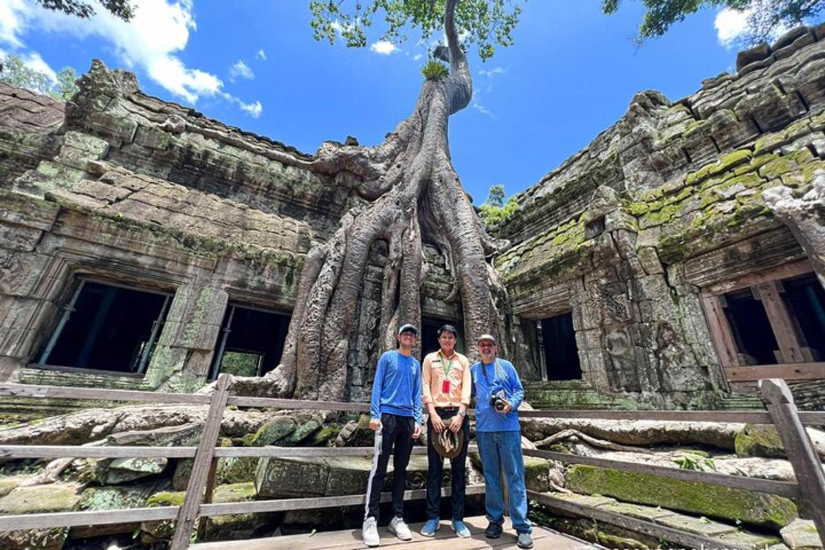 trois personnes debout devant un bâtiment avec un arbre