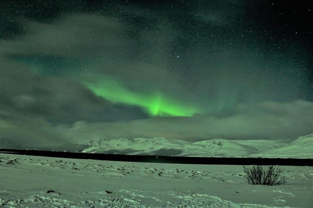 aurora na nebu nad zasneženim poljem