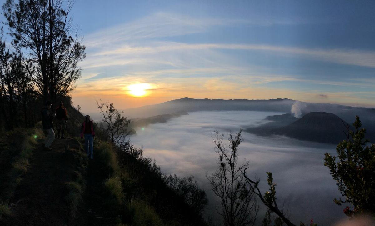 a view of the sun rising over a sea of clouds