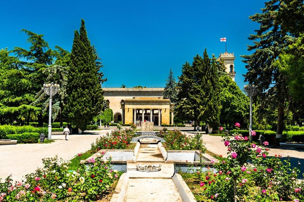 ein Garten mit einem Brunnen und Blumen vor einem Gebäude