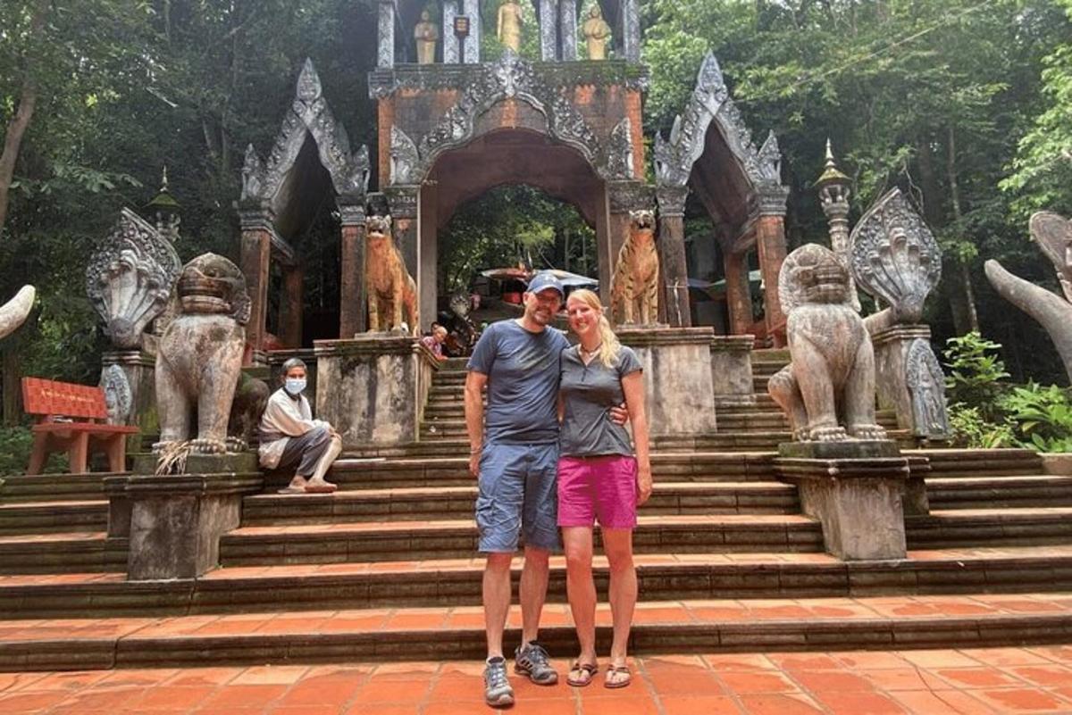 a man and a woman standing in front of a temple