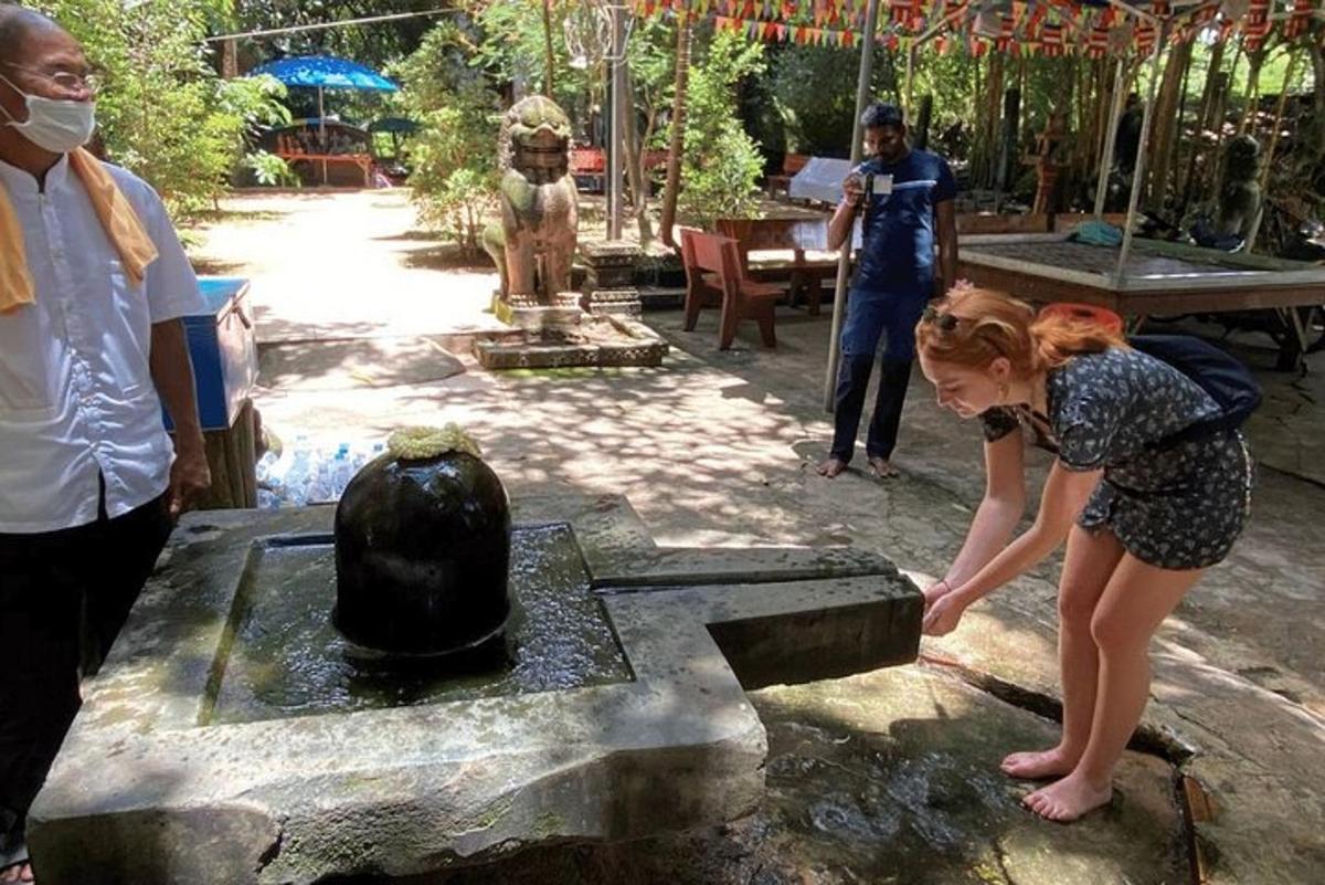 a little girl is playing with a fountain