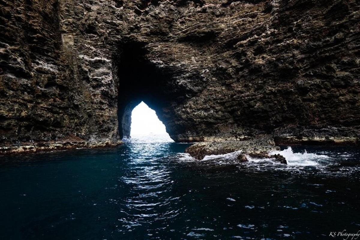 a cave in a rocky mountain with water in it