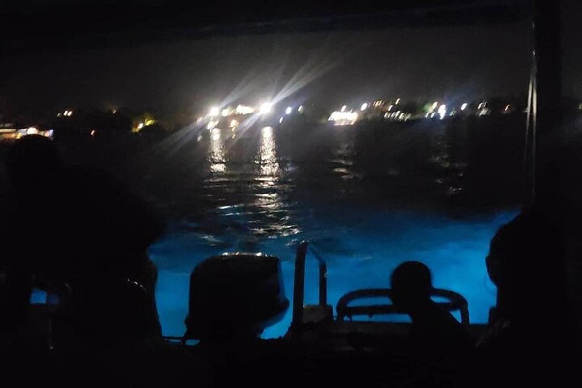 sekumpulan orang di atas bot di sungai pada waktu malam