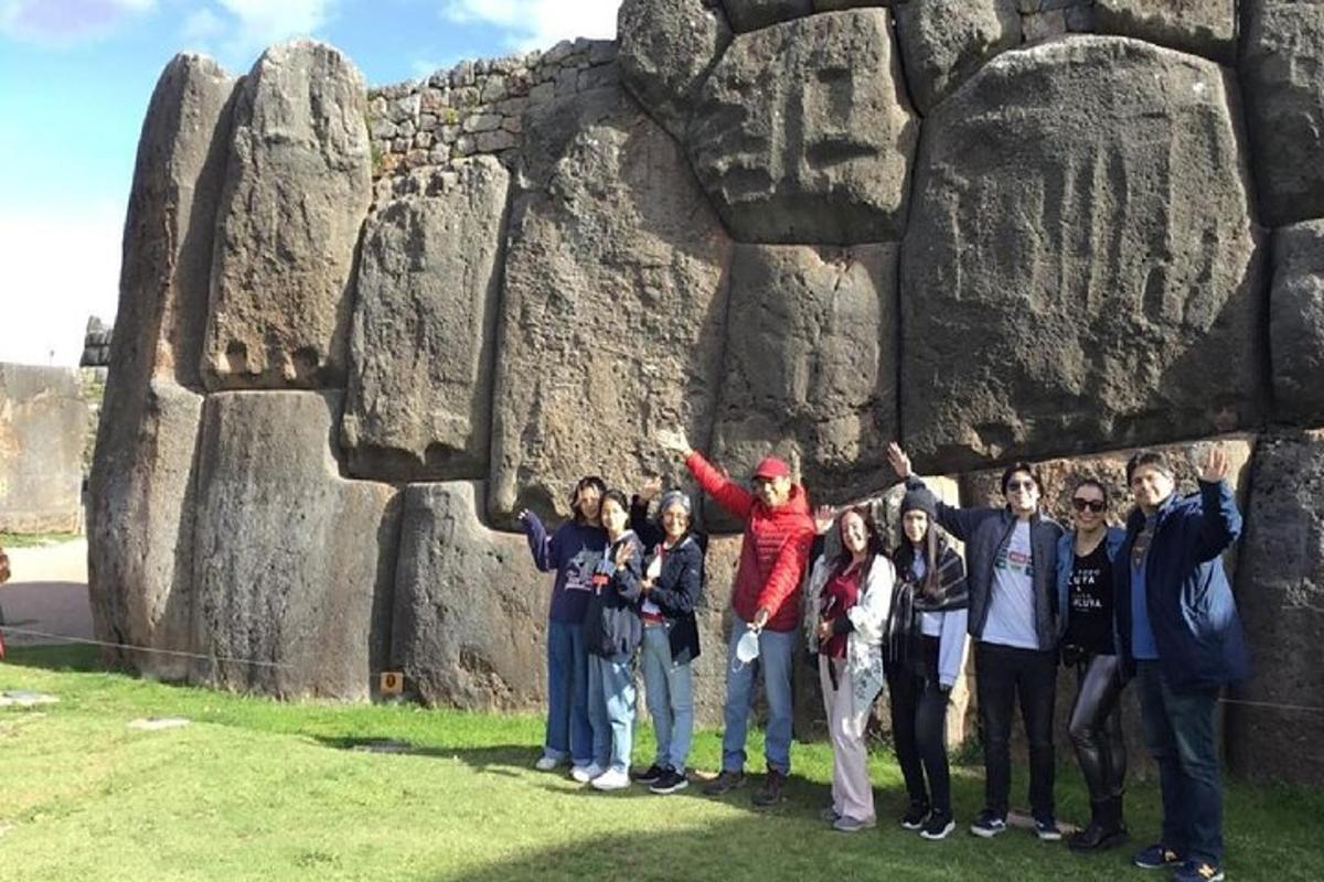 a group of people standing in front of a rock formation