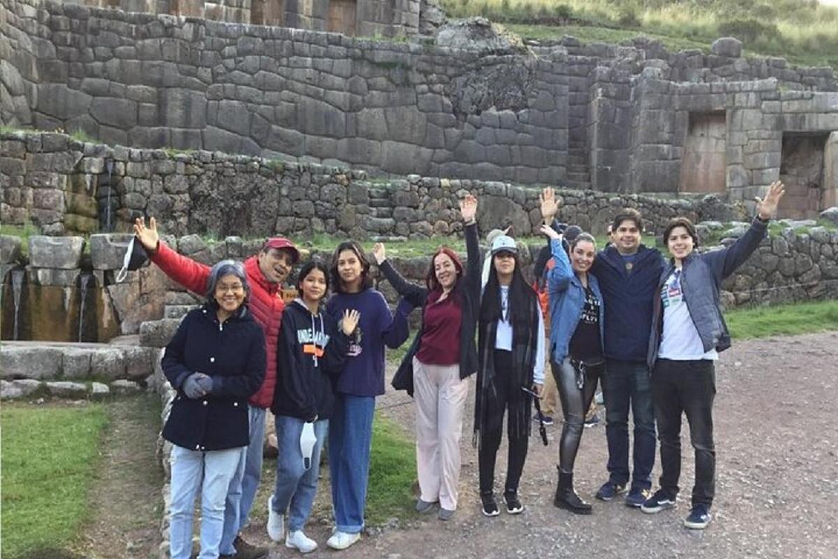 a group of people standing in front of a stone wall