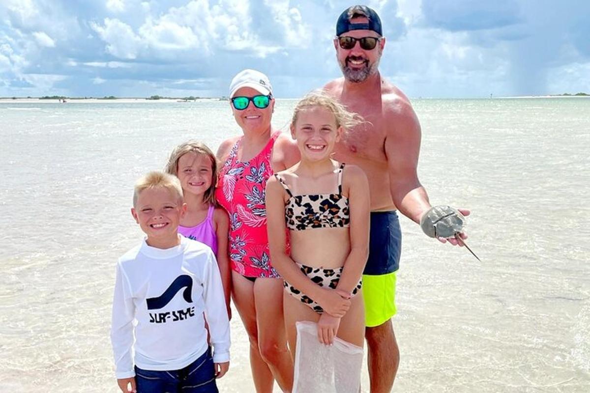 uma família posando para uma foto na praia