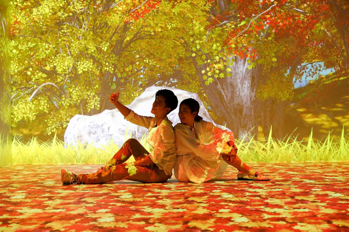 hai người ngồi trên mặt đất trước đài phun nước