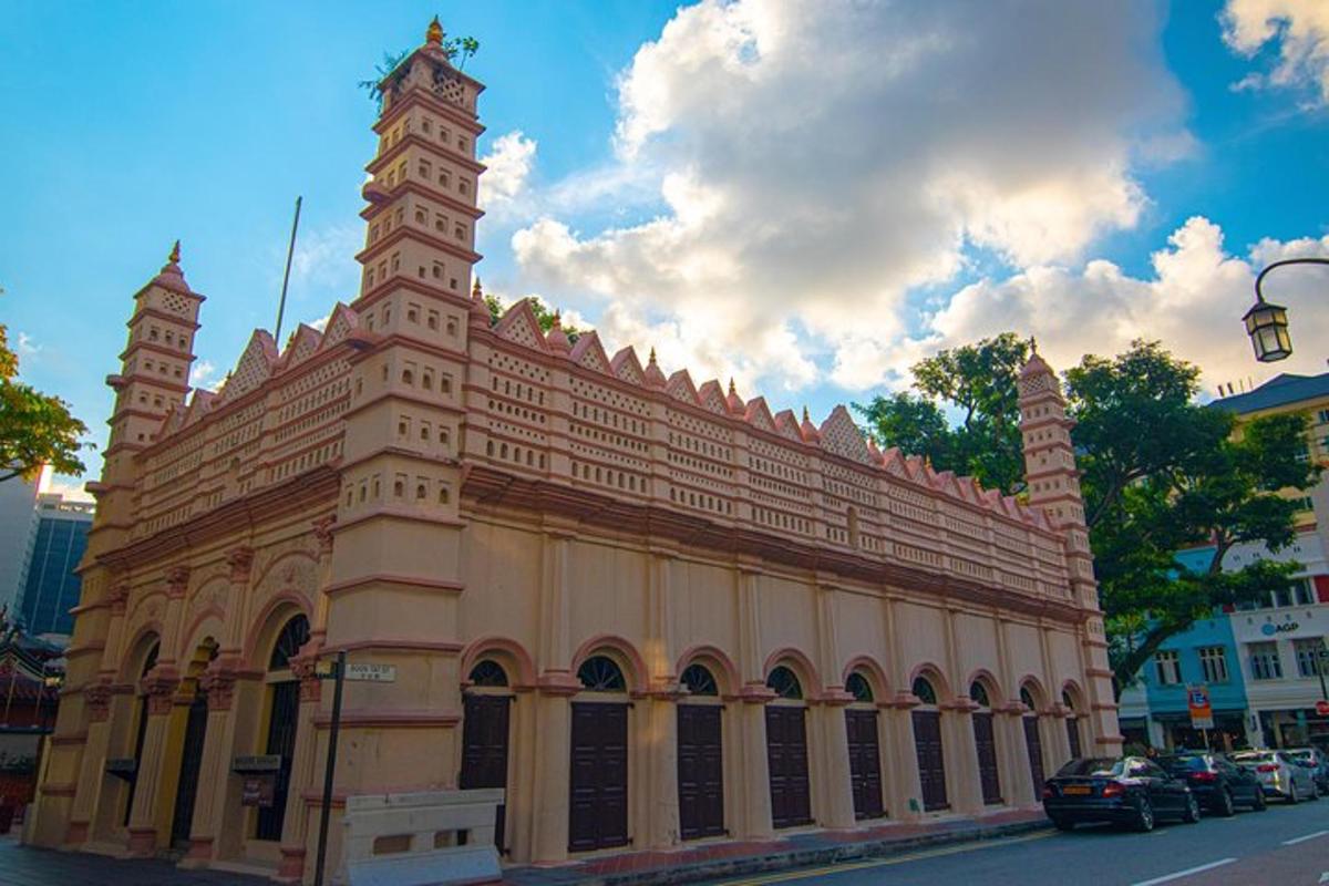 um grande edifício com uma torre de relógio em uma rua