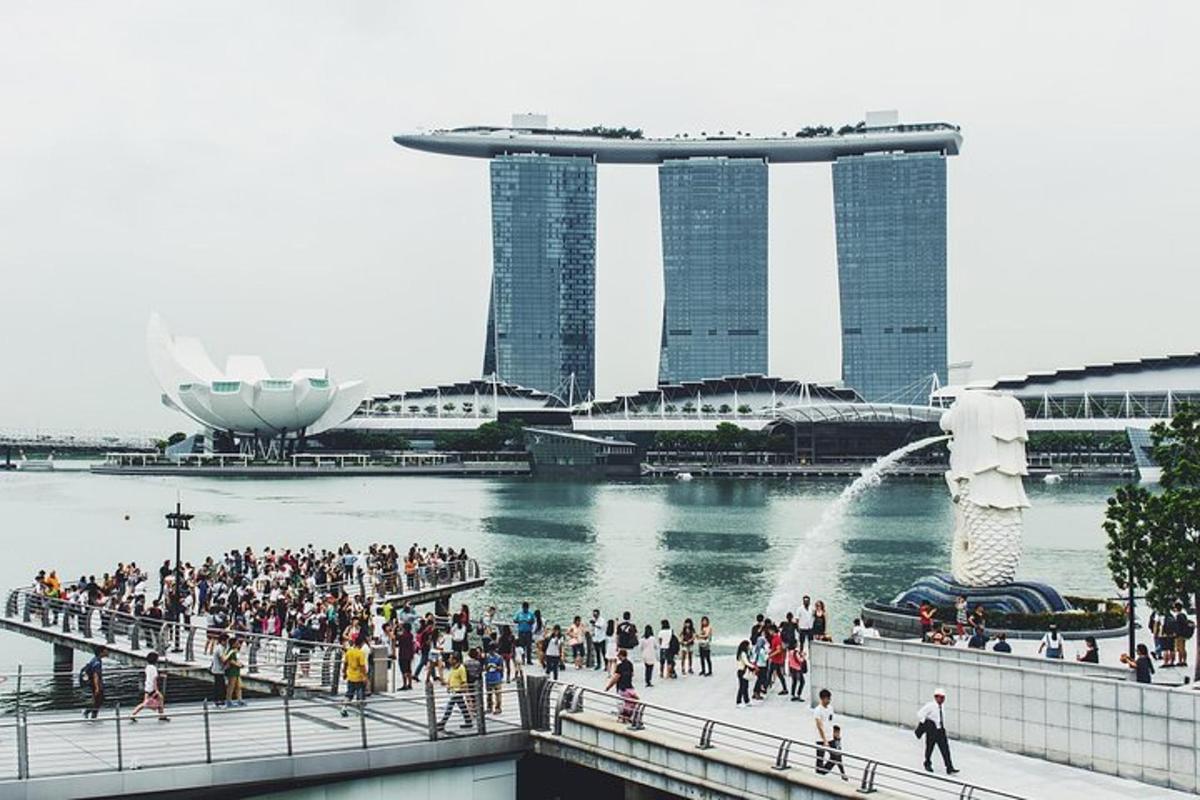 una folla di persone che camminano su un ponte con edifici sullo sfondo