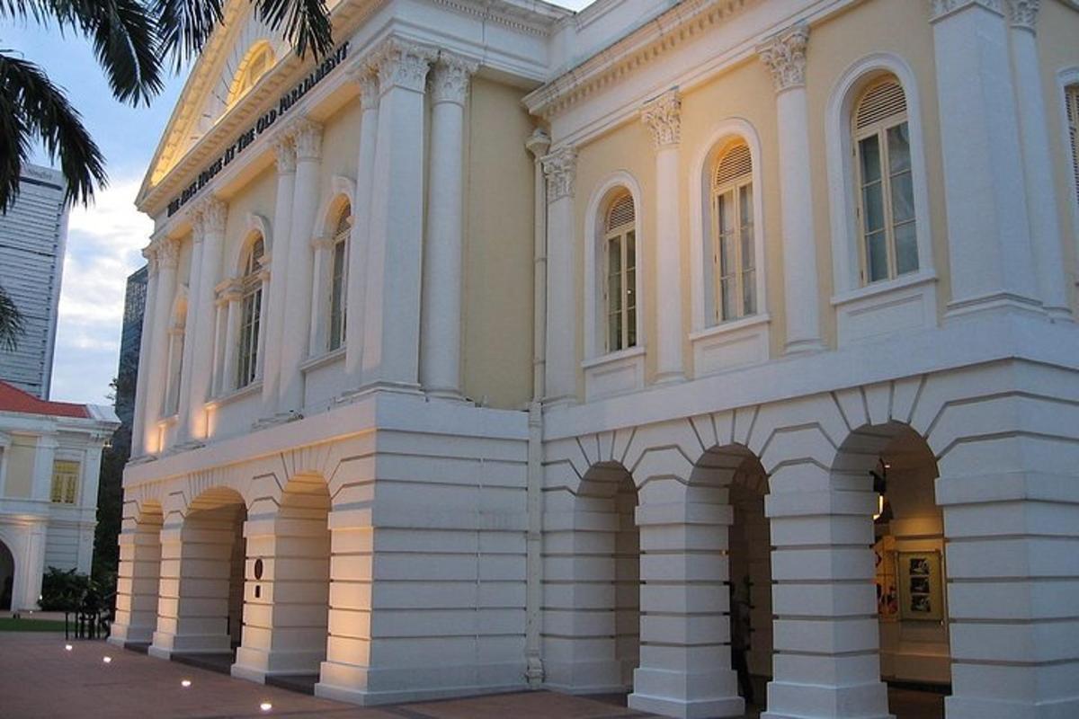 um grande edifício branco com arcos em uma rua