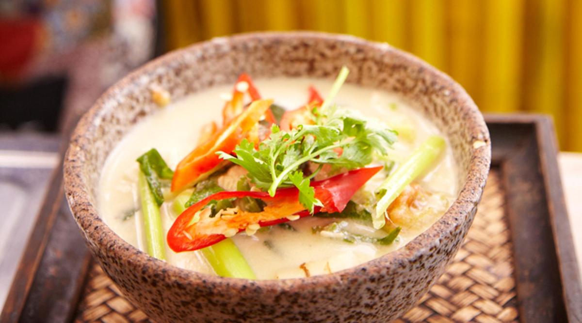 a bowl of soup with vegetables on a table