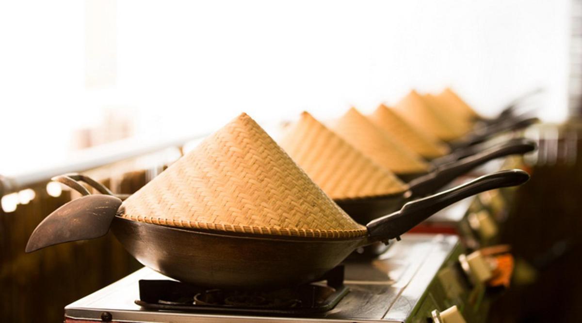 a frying pan with a hat on a stove
