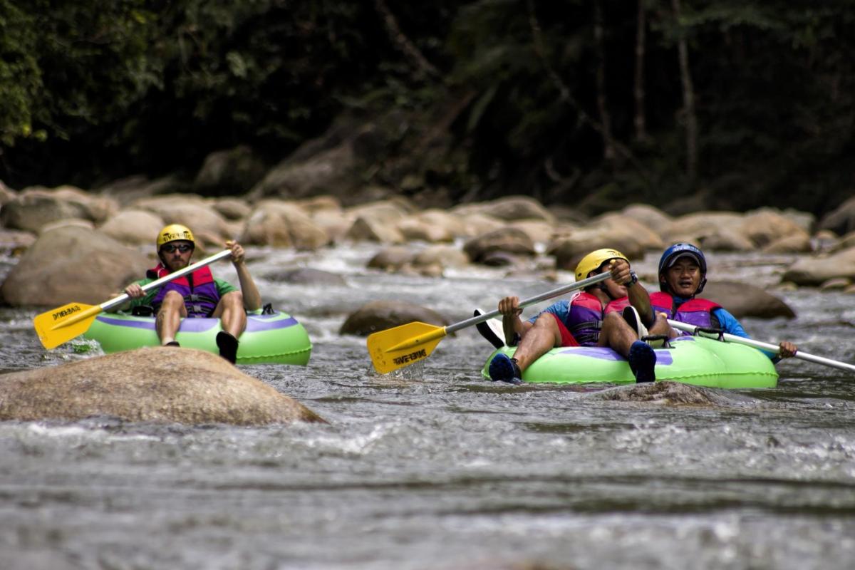 three people are kayaking down a river on a raft
