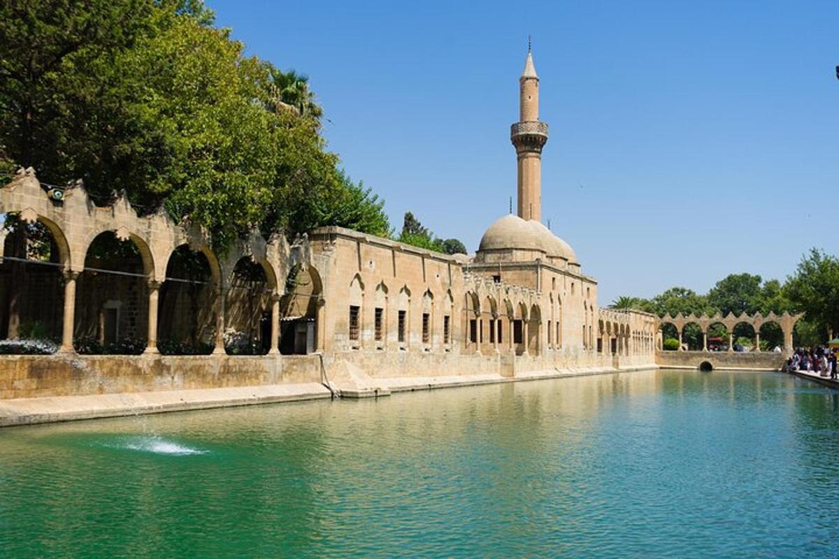 a building with a mosque and a pool of water