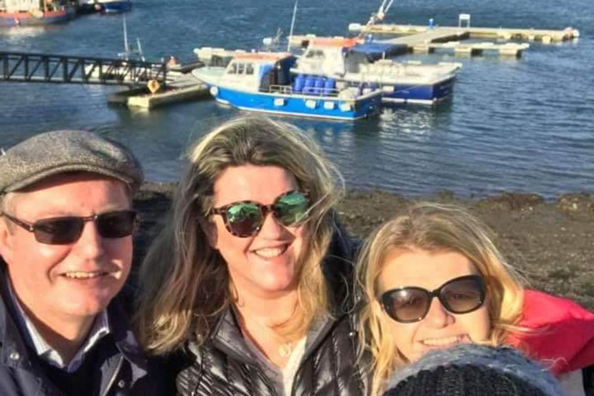 Tveir einstaklingar með sólgleraugu standa við vatnið