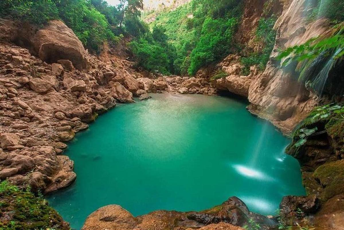 un gran estany d'aigua verda en un canyó rocós