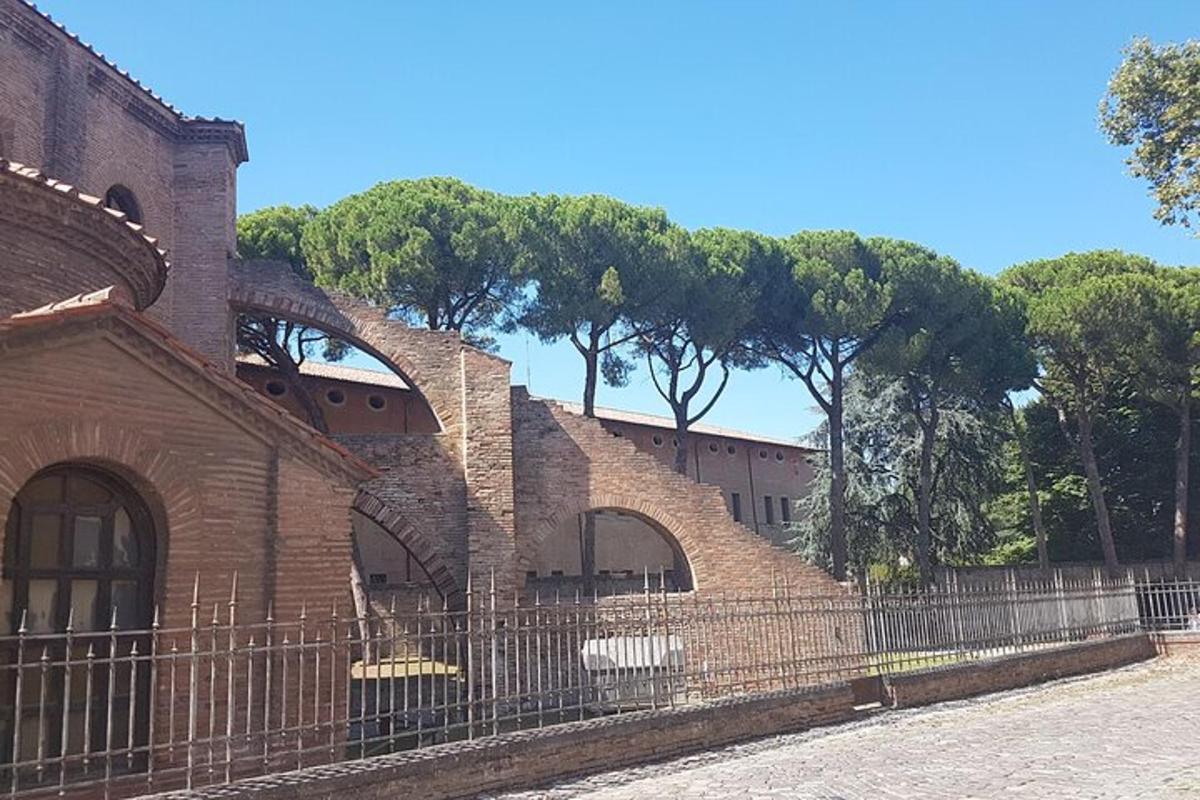 un edifici de maó amb una tanca al costat dels arbres