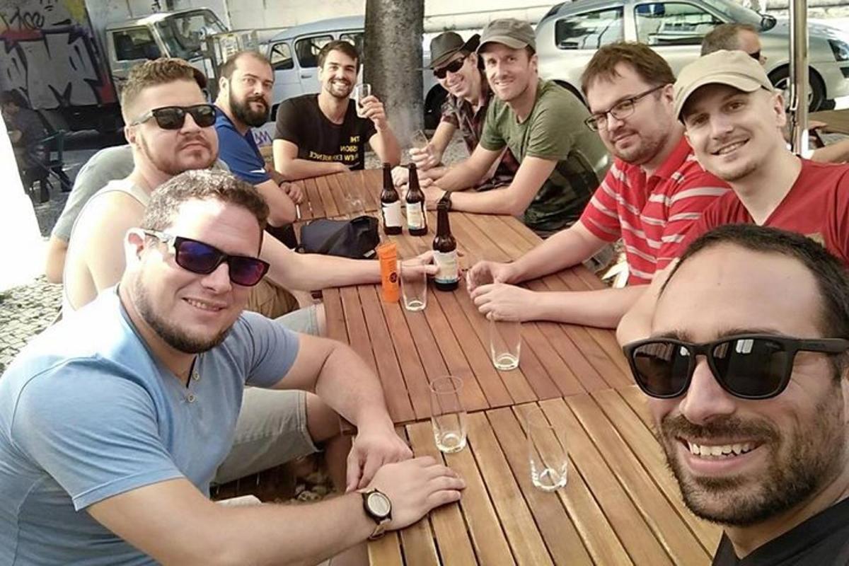 grupp mehi istub puidust laua ümber jookidega