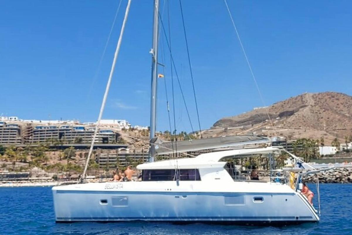 ένα λευκό ιστιοφόρο στο νερό με ανθρώπους πάνω του