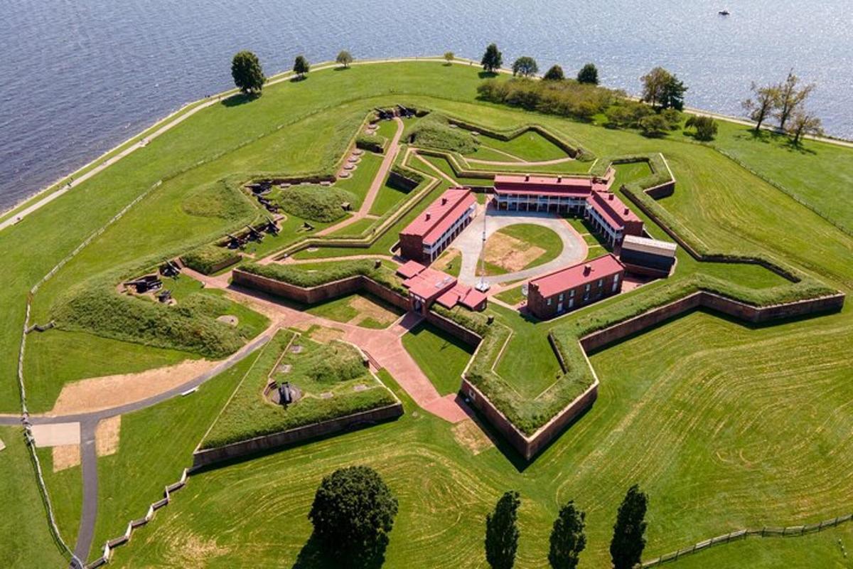 a house on top of a hill next to the water