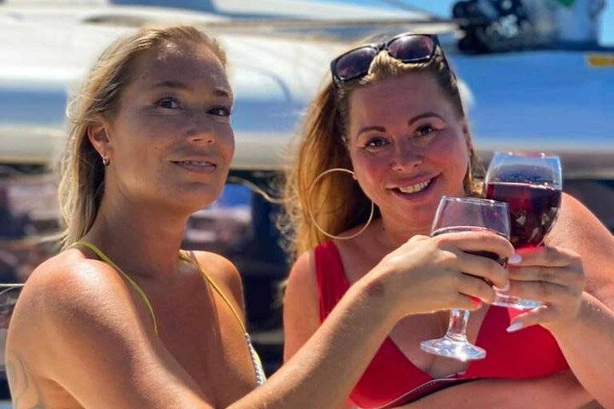 Dos mujeres sostienen copas de vino tinto