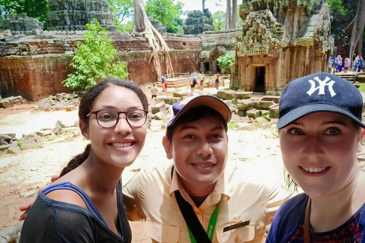 Tres personas posando para una foto frente a un templo.