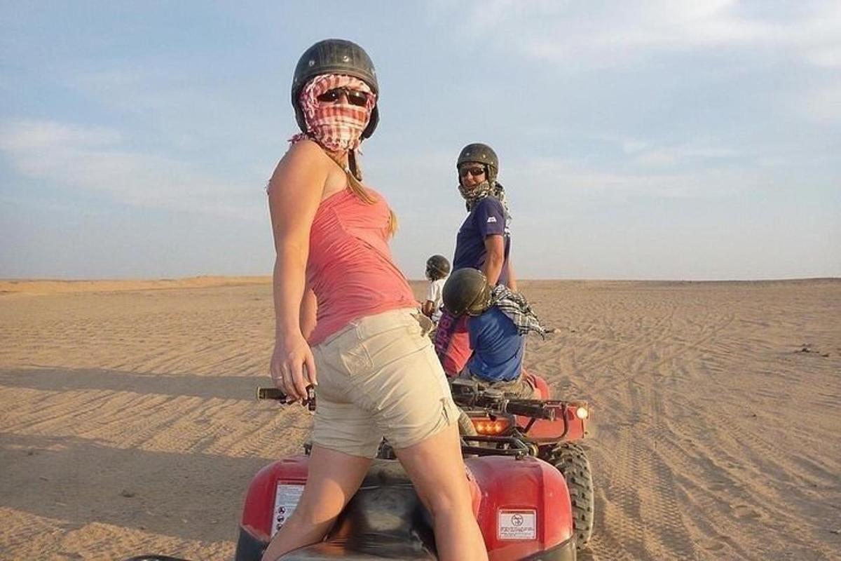 duas pessoas em um quadriciclo no deserto