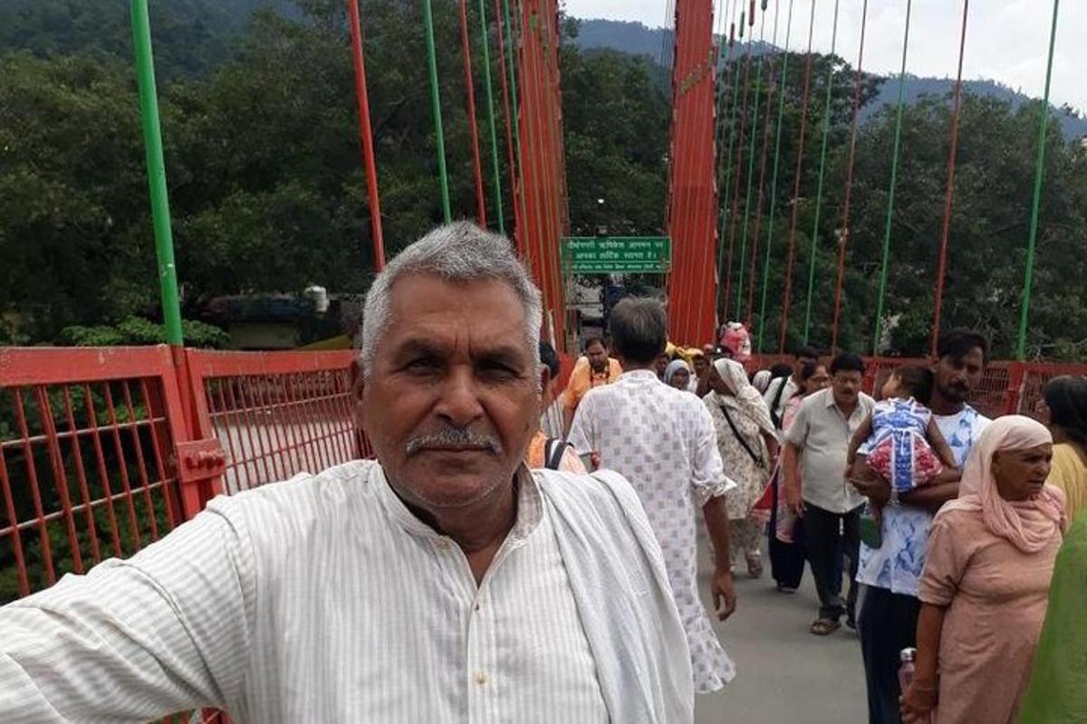 an older man standing on a suspension bridge