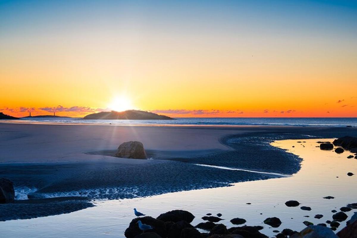 a sunset on a beach with the sun setting