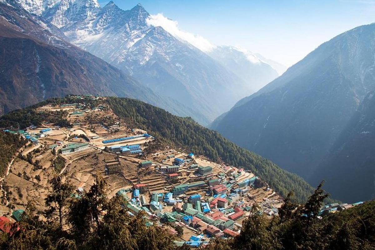a town on a hill with mountains in the background