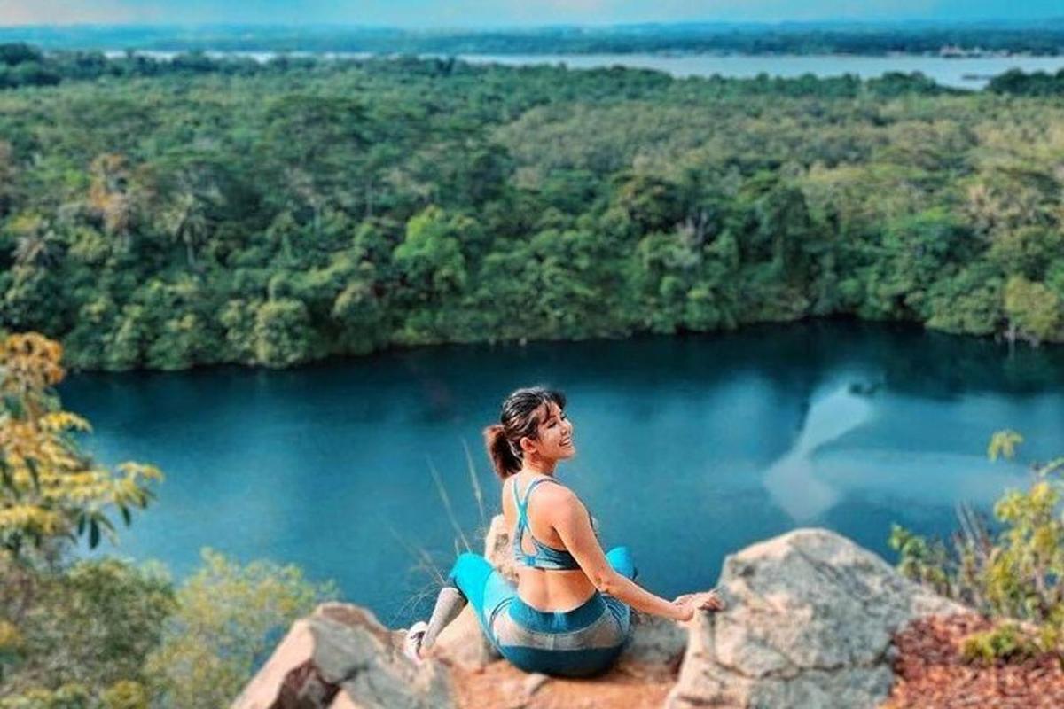 žena sedící na skále s výhledem na jezero