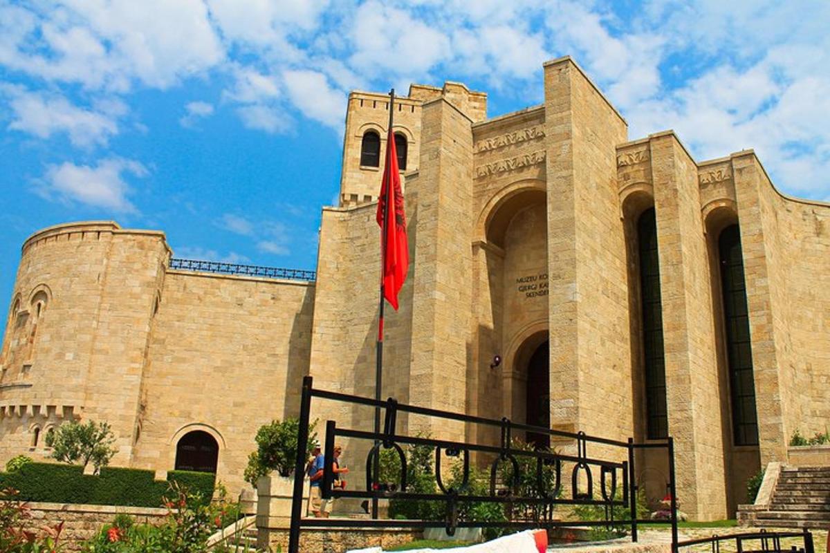 Un gran edificio con una bandera roja delante.