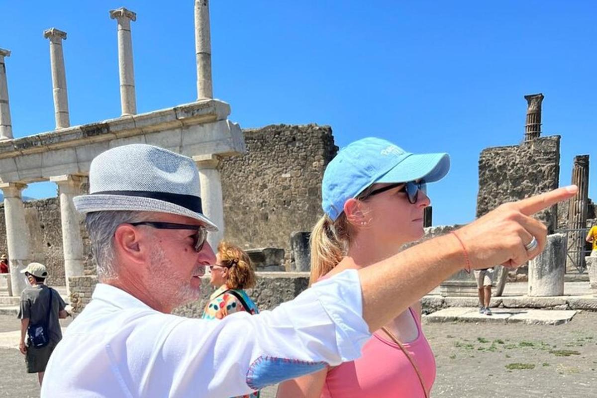 un uomo e una donna che indicano le rovine