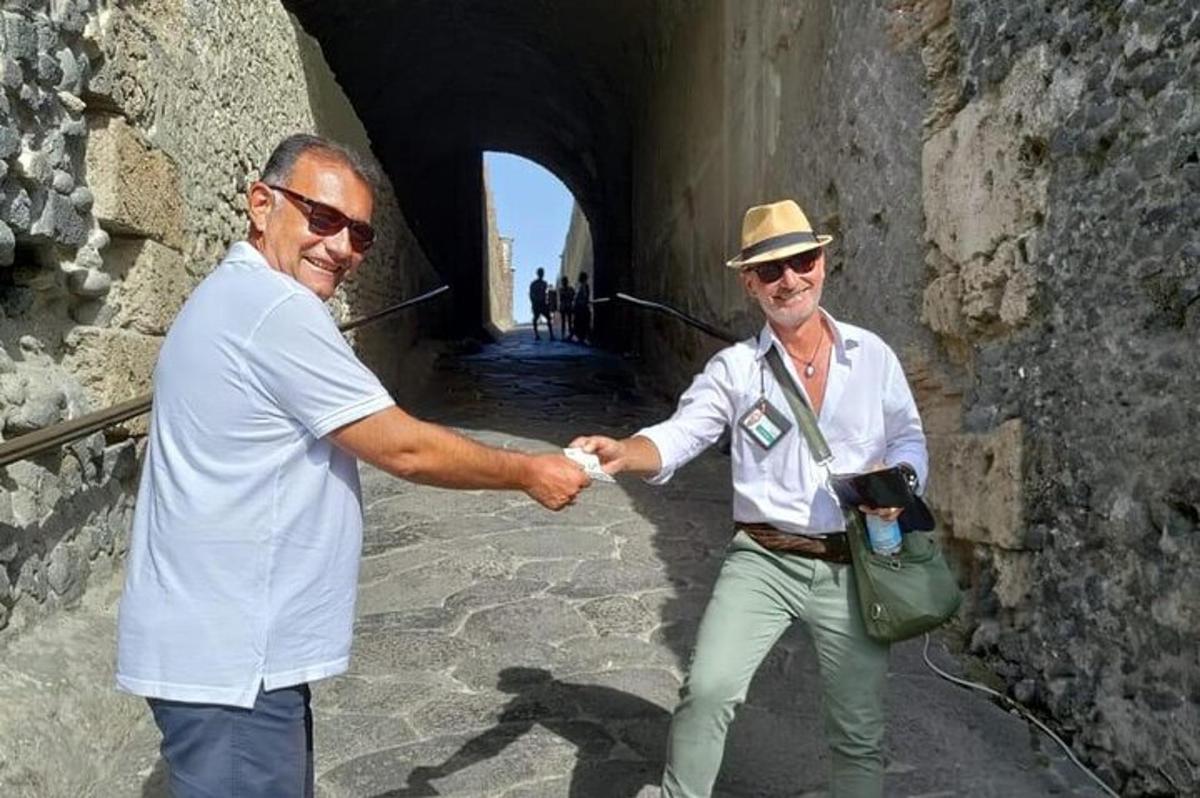 two men shaking hands while standing in a tunnel