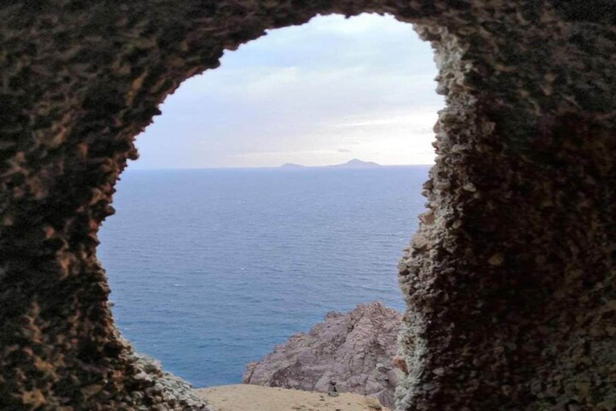 a view of the ocean through a hole in a rock