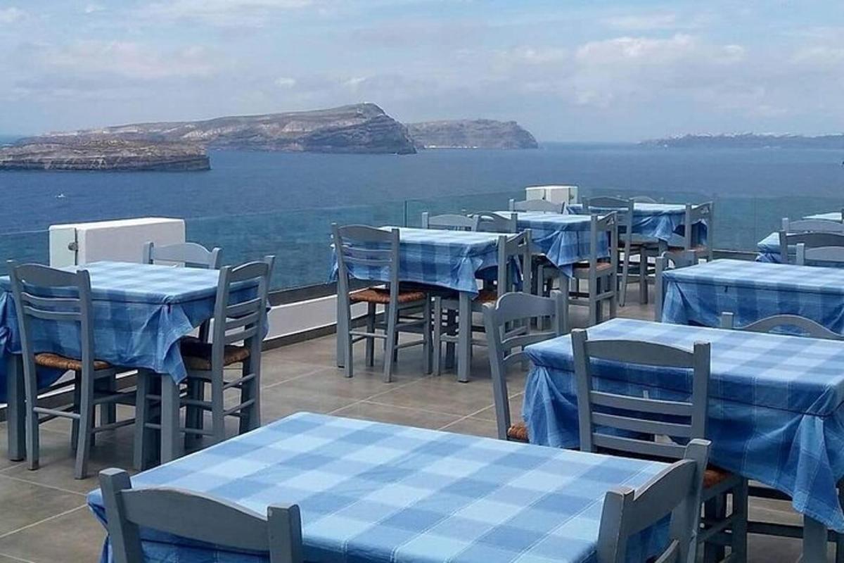 a row of tables and chairs with the ocean in the background