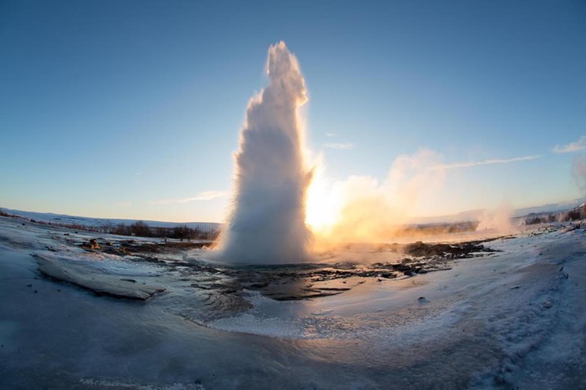 en geysir spyr vann opp i himmelen
