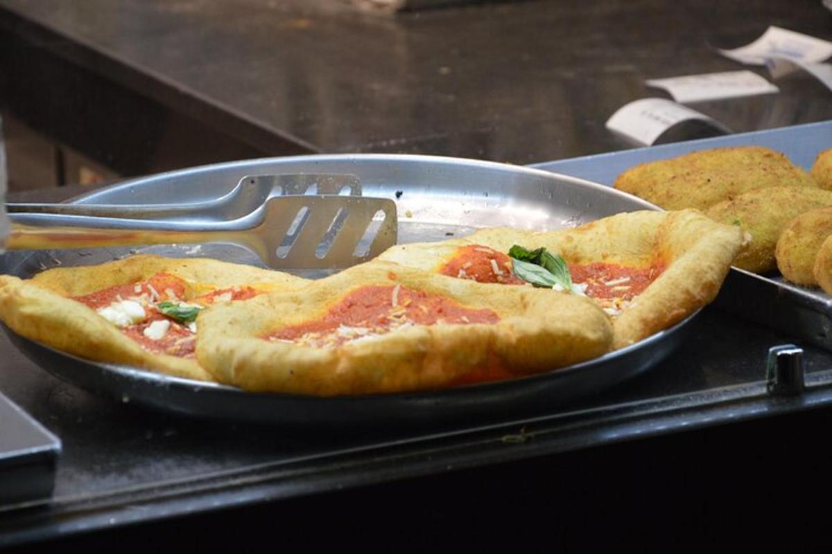 pizza dalam kuali dengan spatula di atas meja