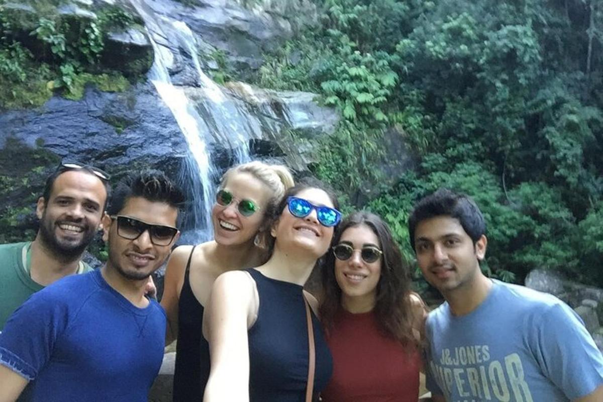 un gruppo di persone in piedi davanti a una cascata