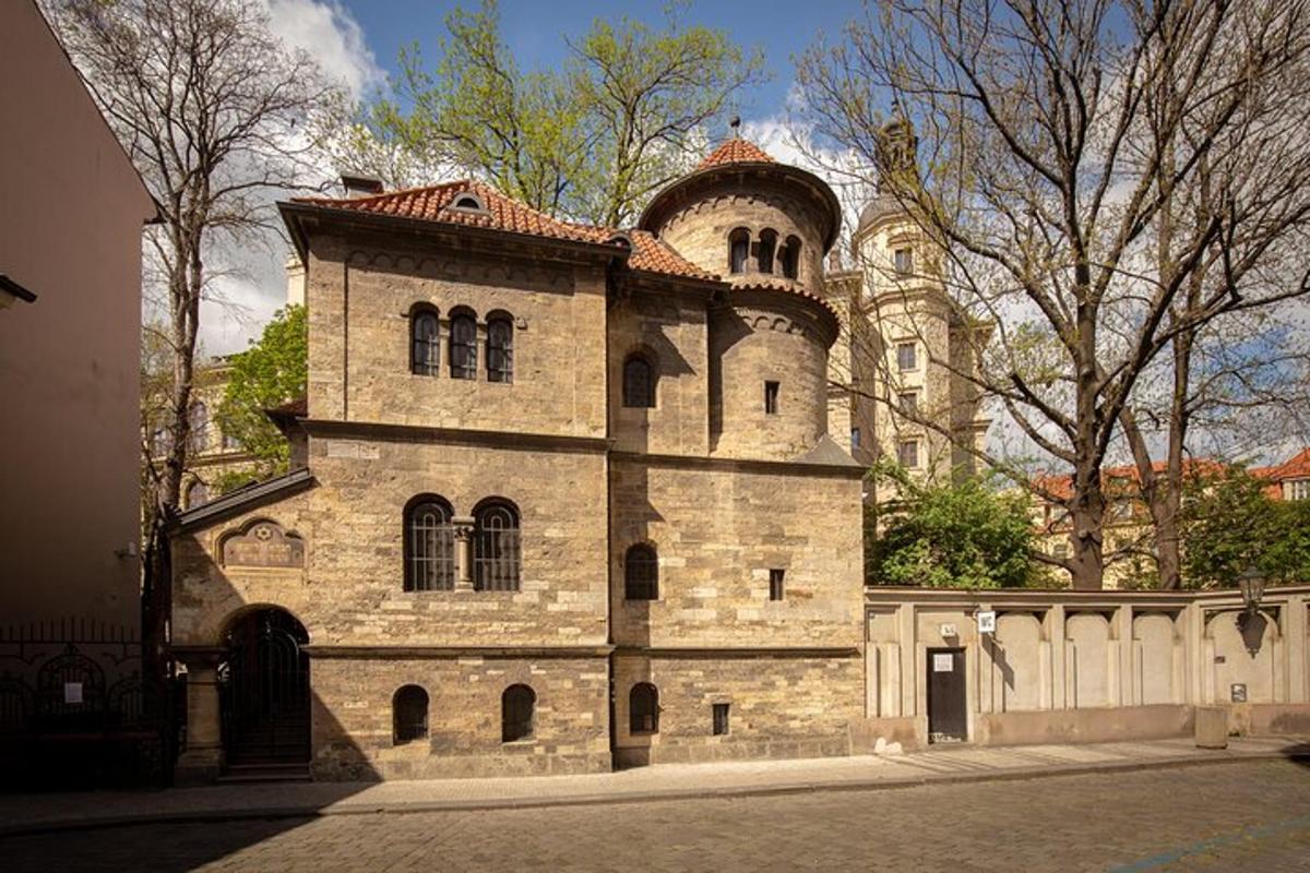 un grande edificio in pietra con una torre su una strada