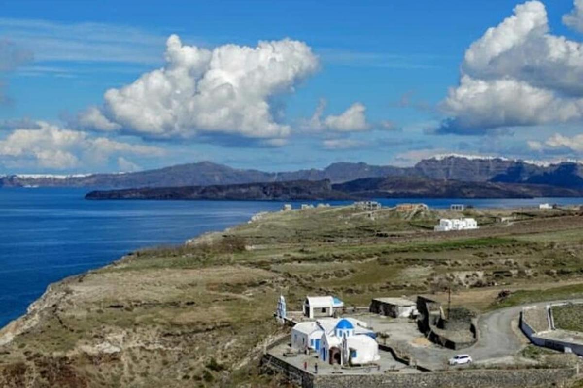 a group of white tents on a hill next to the water