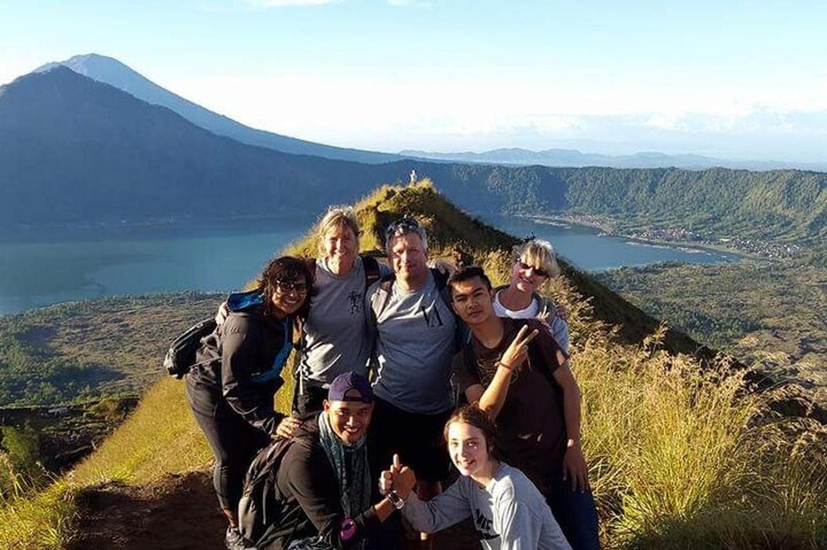 a group of people posing for a picture on a mountain