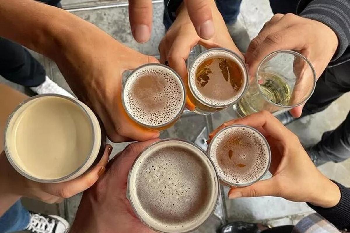 sekumpulan orang mengangkat cawan bir mereka