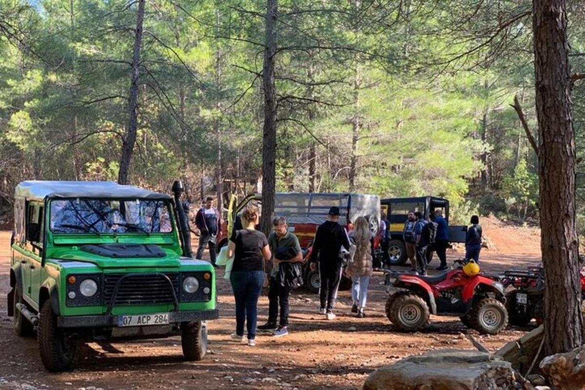 a group of people standing around a jeep in a forest
