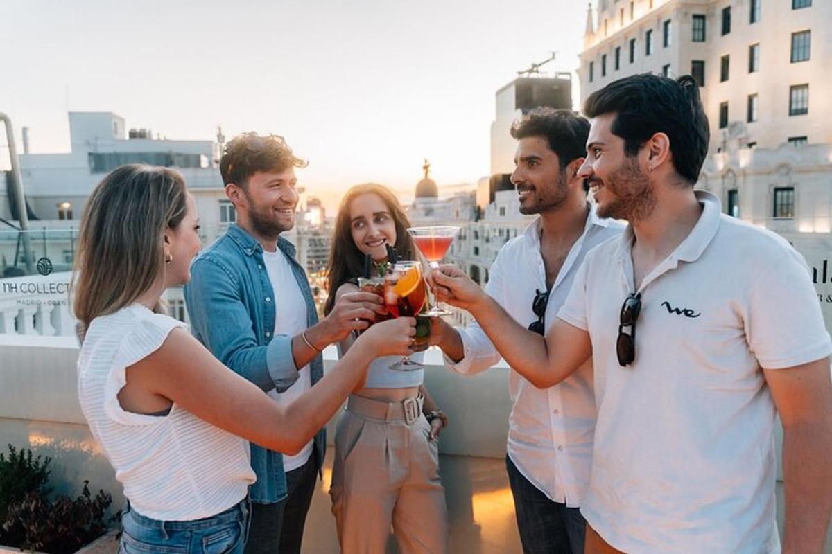 un gruppo di persone che tengono in mano dei drink su un tetto